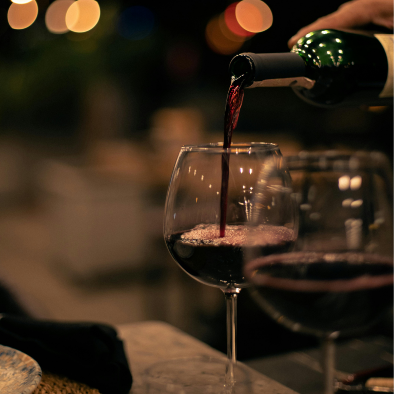 Un sommelier che serve vino in calici da degustazione professionali per un'accoglienza d'autore